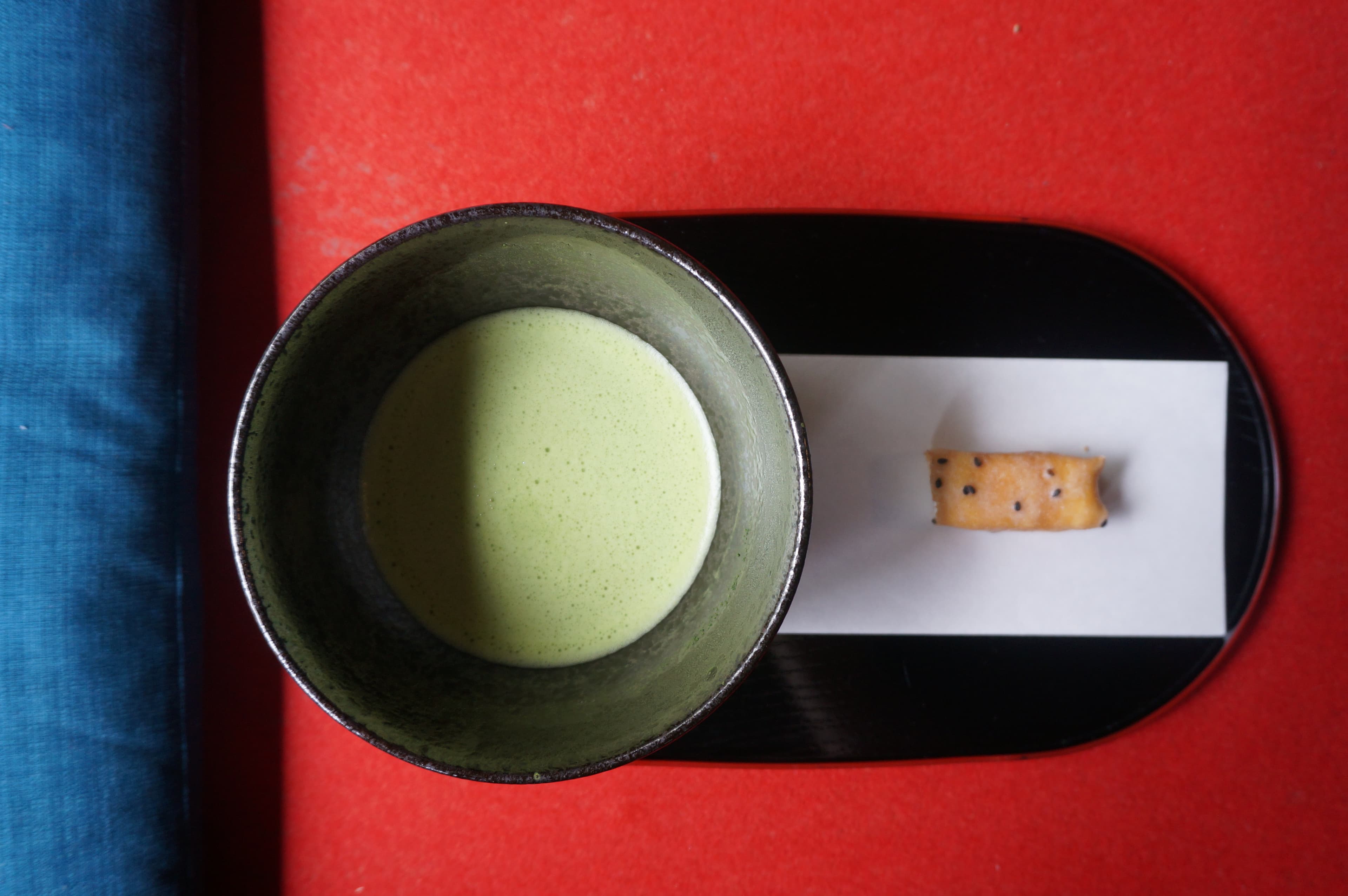 A bowl of matcha tea and a traditional Japanese sweet, evoking calm and quiet ritual