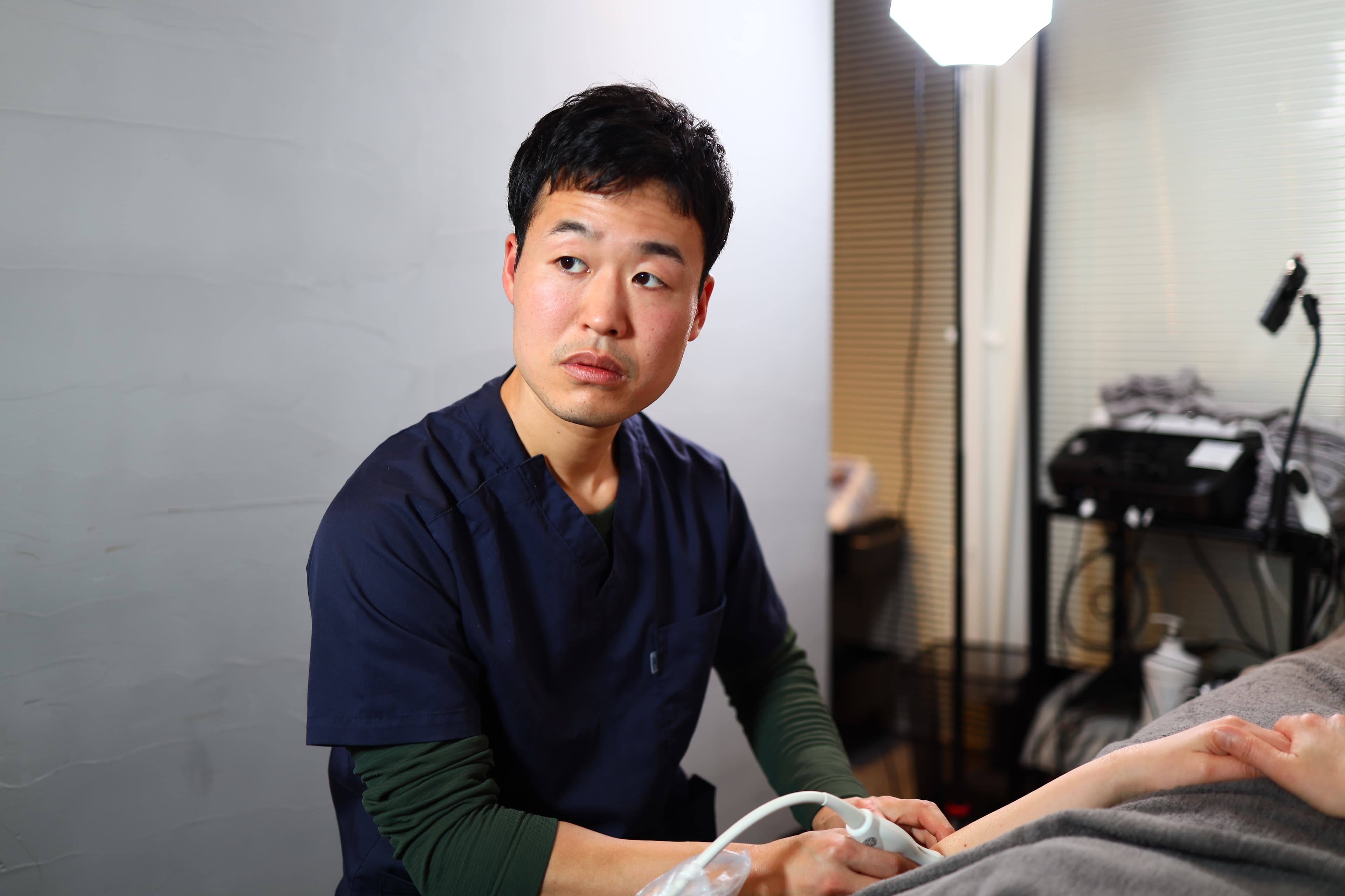 Soichiro Funo using ultrasound imaging during a clinical assessment
